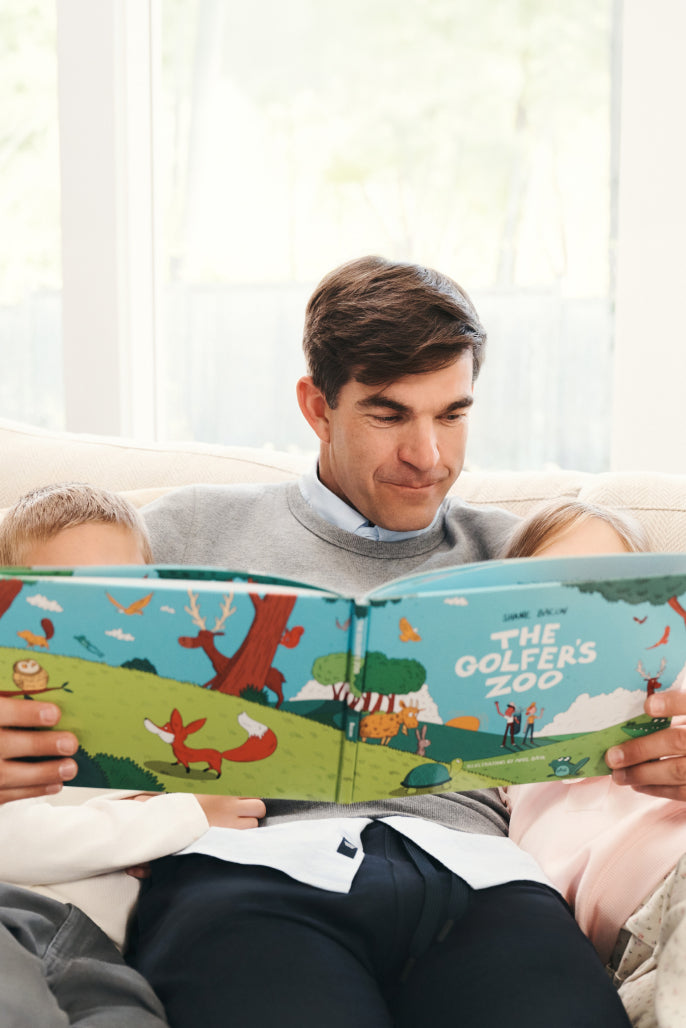 Man with his children reading the golfer's zoo book