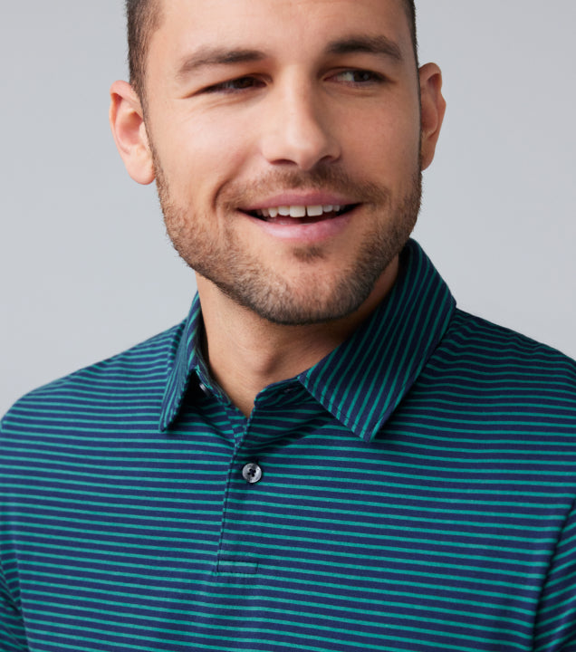 chest up image of a man wearing a teal and black striped polo.