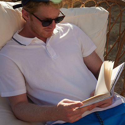 man reads a book in the sunshine wearing Mack Weldon clothing