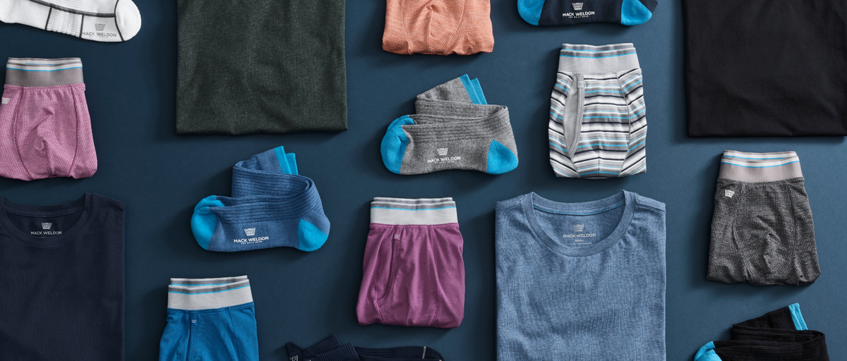 birds-eye view of Mack Weldon clothing laid out on a navy blue ground