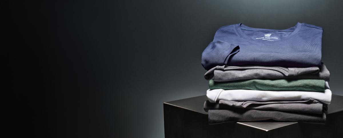 image of a stack of SILVER shirts folded on top of a metal cube