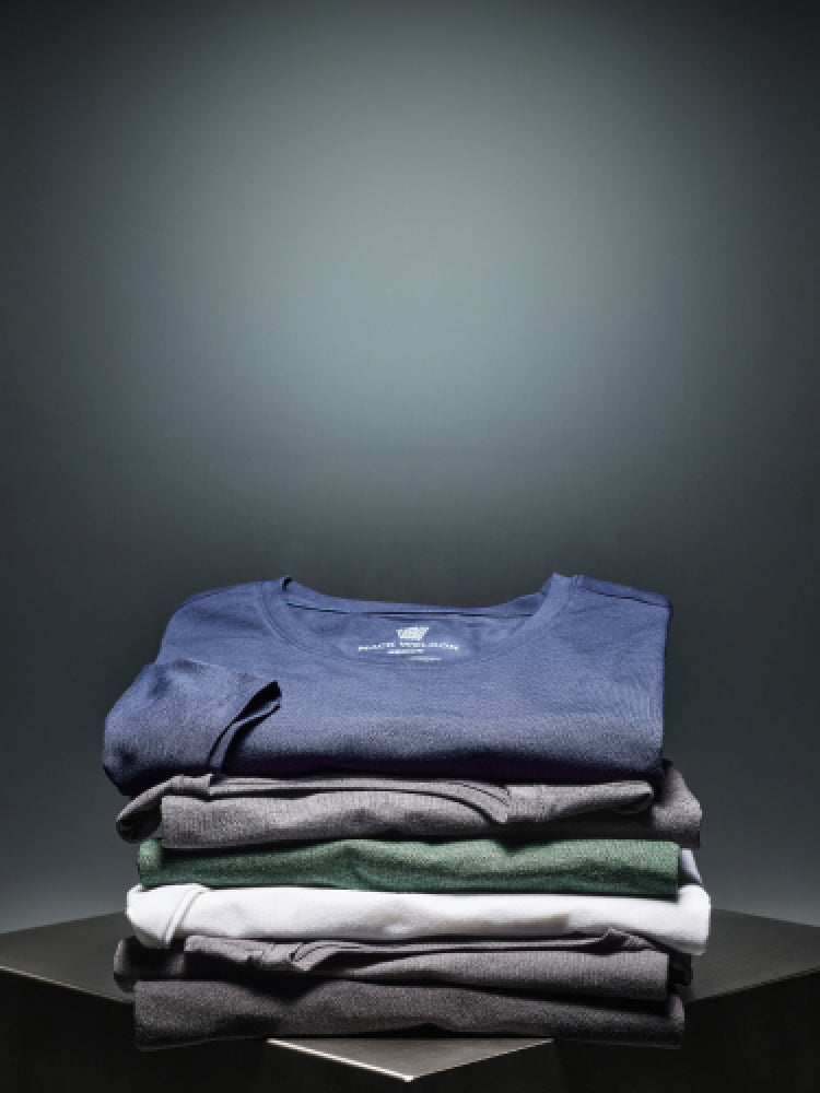 image of a stack of SILVER shirts folded on top of a metal cube